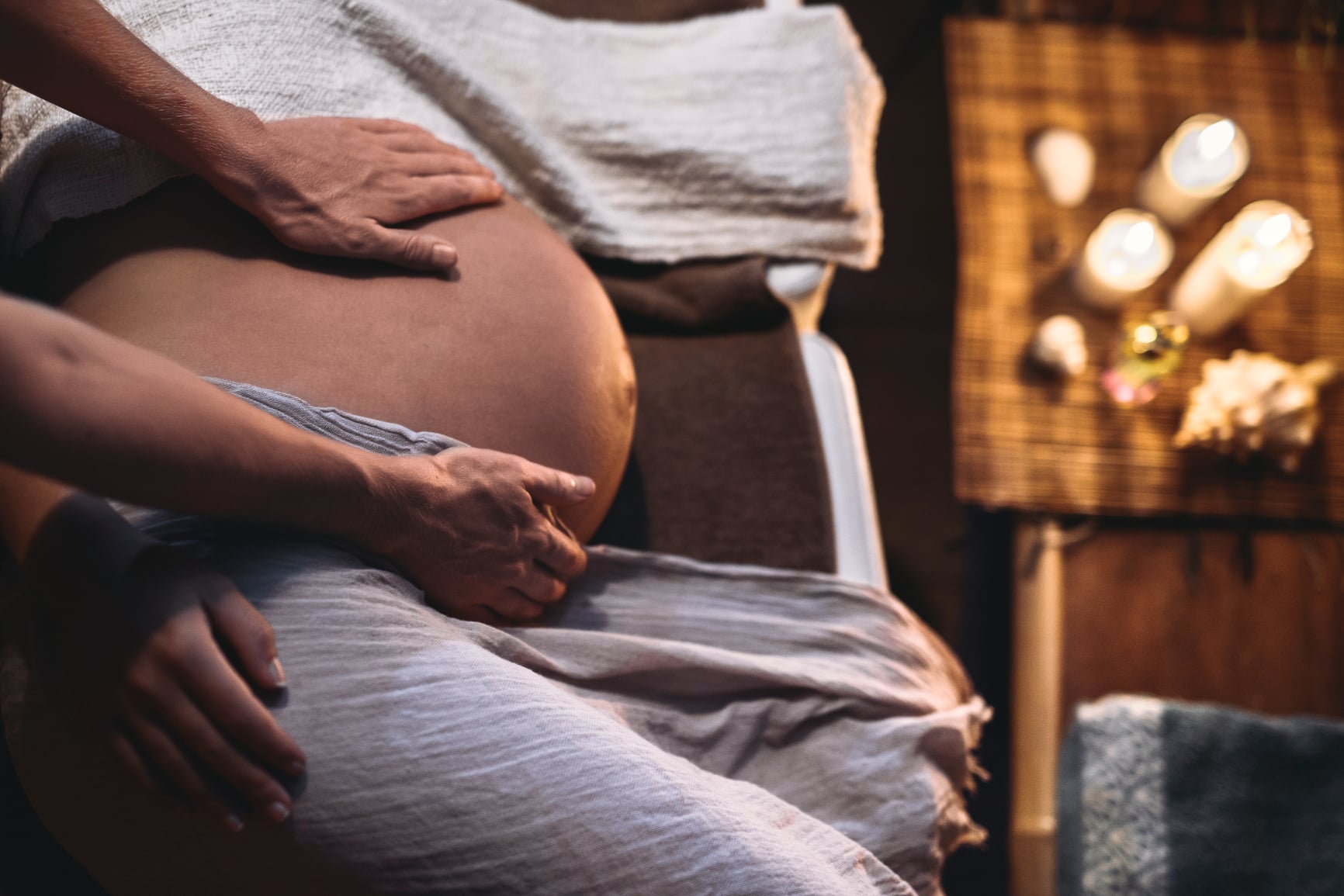 Doula touches the belly of a pregnant woman.